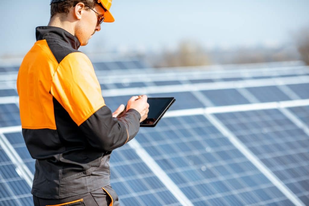 Engineer servicing solar panel on electric plant