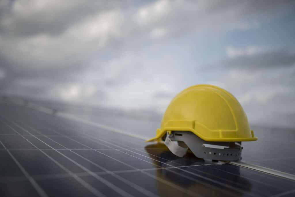 Yellow safety helmet on solar cell panel