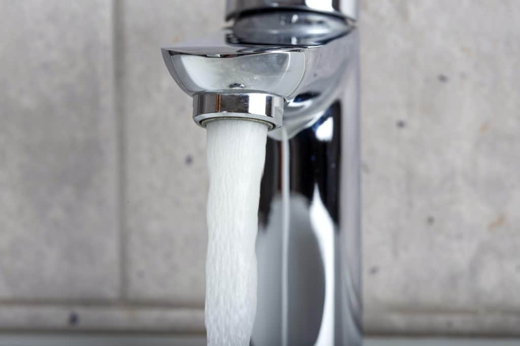 Flowing water from a modern designer chrome water tap