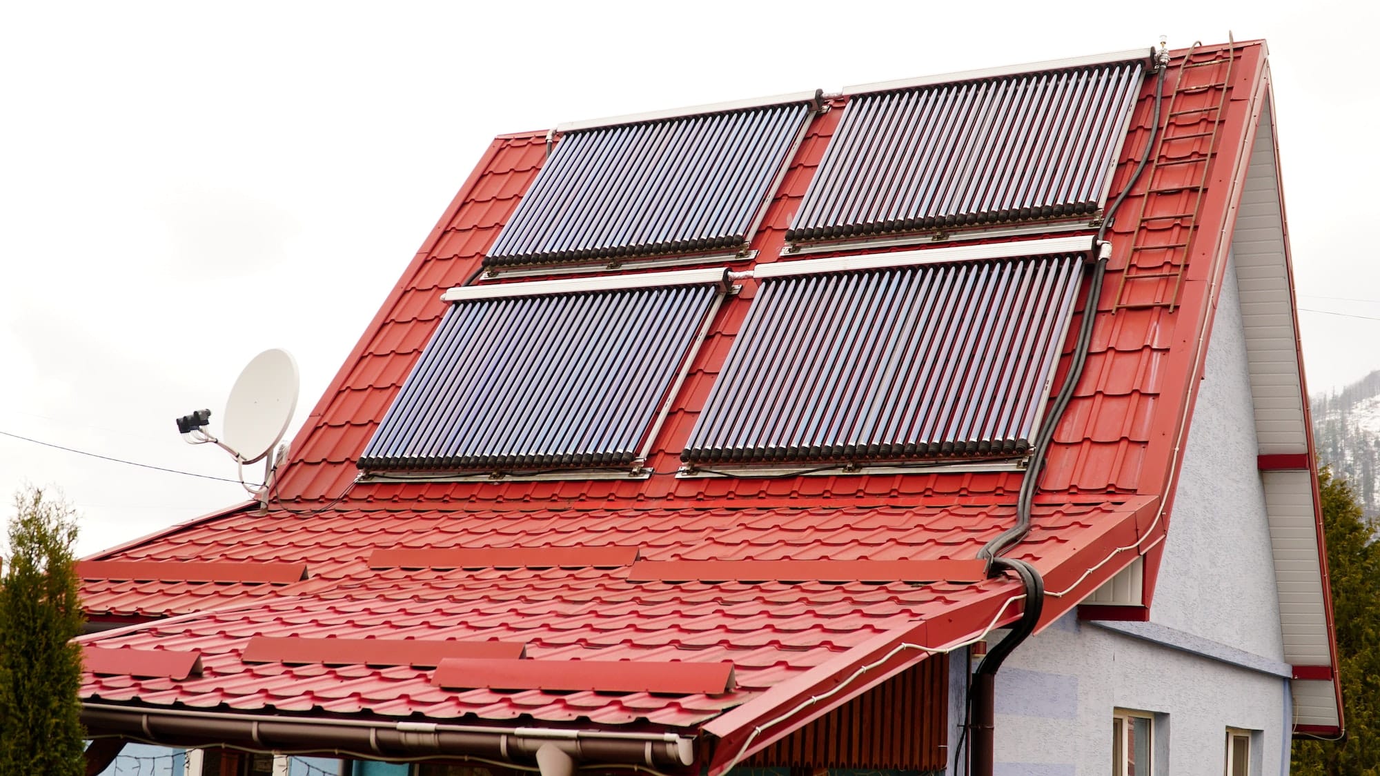 Solar glass tube hot water panel array mounted on a tiled roof. water heating batteries.